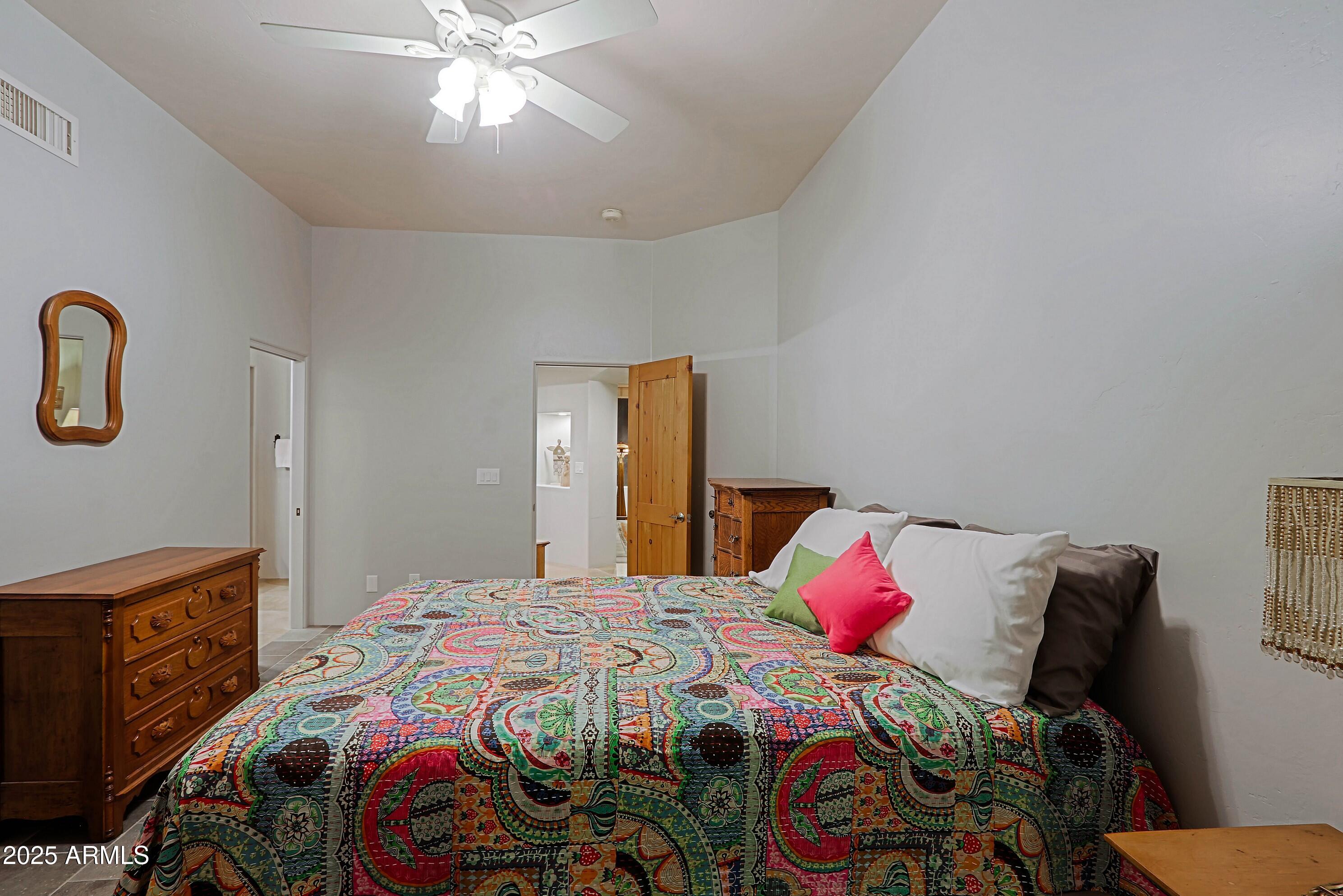 41840 North Spur Cross Road Cave Creek, AZ 85331 - Photo 57 of 67 a bedroom with a bed and a chandelier