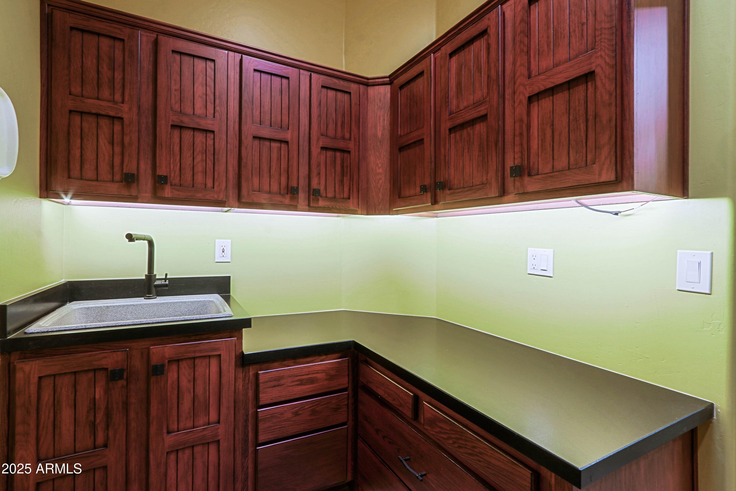 41840 North Spur Cross Road Cave Creek, AZ 85331 - Photo 67 of 67 a kitchen with wooden cabinets and a sink