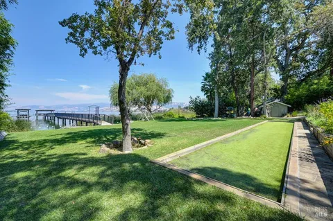 a view of a patio with table and chairs and floor to ceiling window with wooden floor