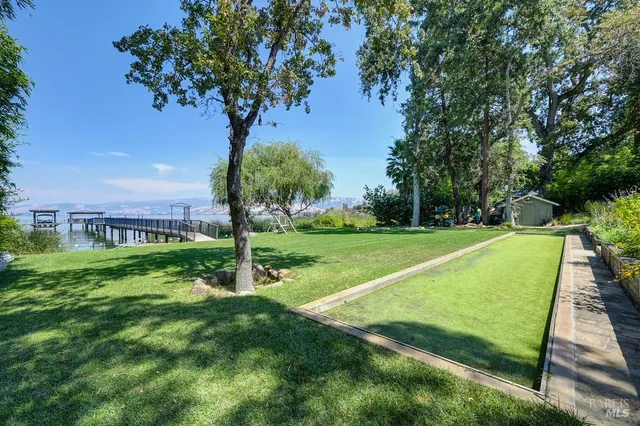 a view of a patio with table and chairs and floor to ceiling window with wooden floor
