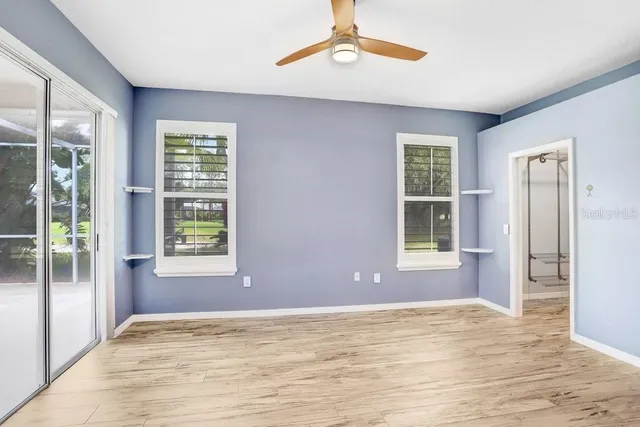 a view of an empty room with window and wooden floor