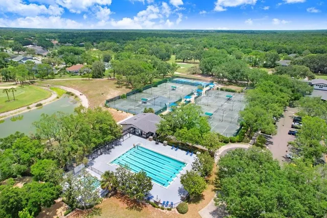 an aerial view of residential houses with outdoor space and lake view