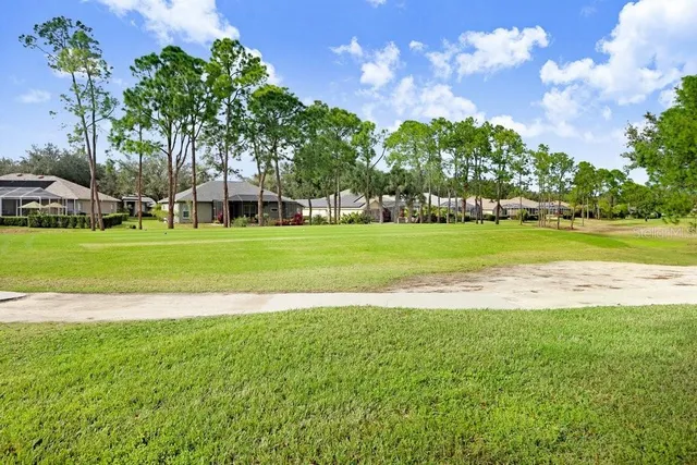 a view of a sign in front of a house with a garden