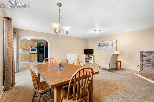 2125 Winston Road Colorado Springs, CO 80909 - Photo 6 of 37 Dining room with an inviting chandelier and light colored carpet