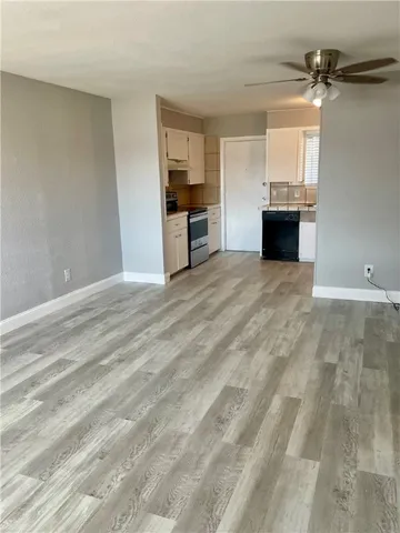 a kitchen with stainless steel appliances granite countertop a sink and cabinets with wooden floor