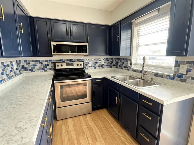 a kitchen with a sink stove and microwave