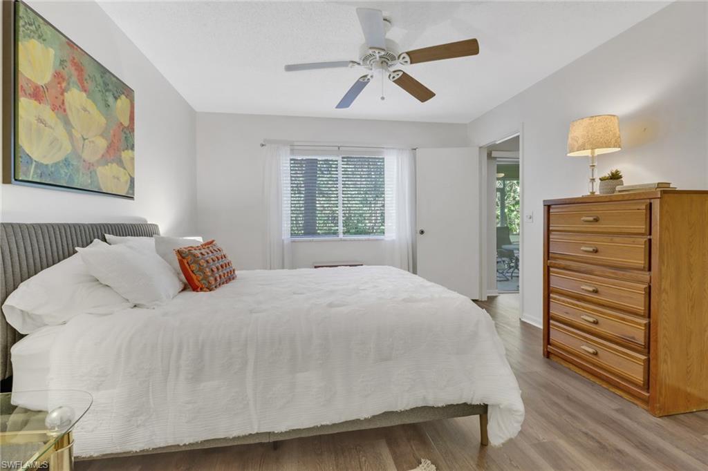 7791 Esmeralda Way, Unit L103 Naples, FL 34109 - Photo 16 of 46 a bedroom with a bed and wooden floor