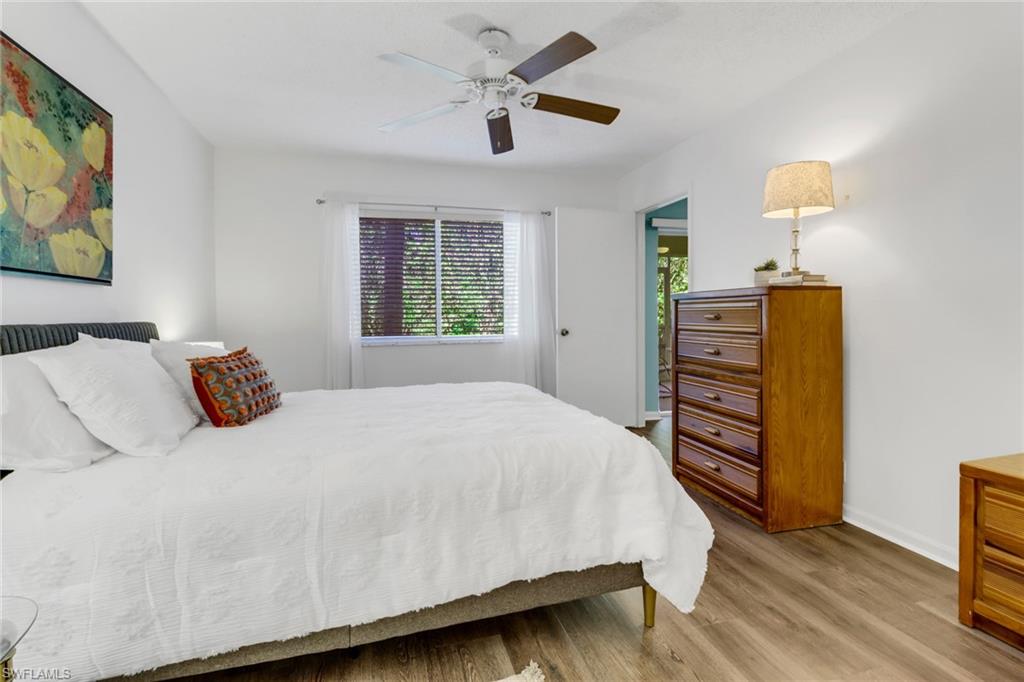 7791 Esmeralda Way, Unit L103 Naples, FL 34109 - Photo 18 of 46 a bedroom with a bed and a chandelier