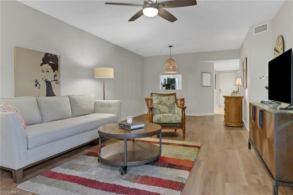 7791 Esmeralda Way, Unit L103 Naples, FL 34109 - Photo 2 of 46 a living room with furniture and a flat screen tv