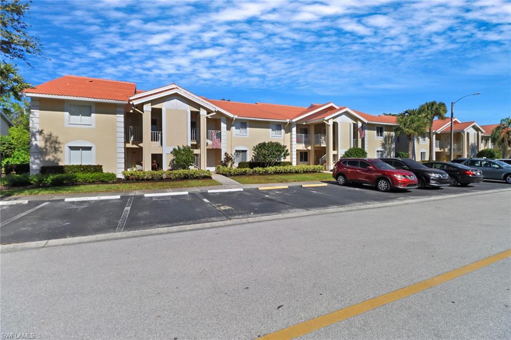 7791 Esmeralda Way, Unit L103 Naples, FL 34109 - Photo 24 of 46 a front view of a house with a yard