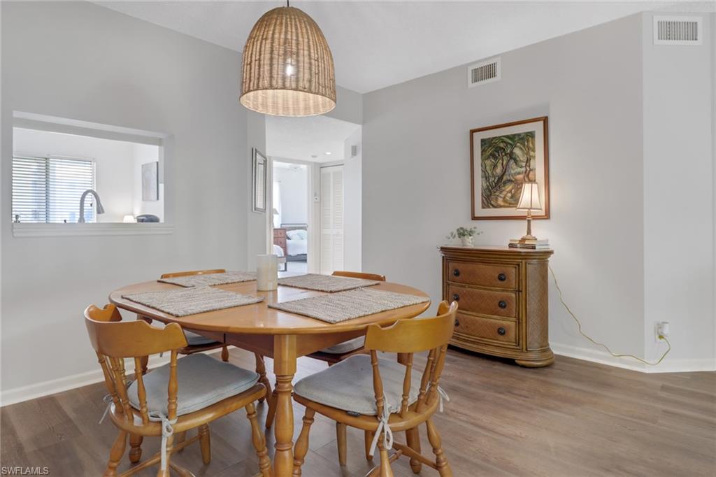 7791 Esmeralda Way, Unit L103 Naples, FL 34109 - Photo 3 of 46 a view of a dining room with furniture and wooden floor