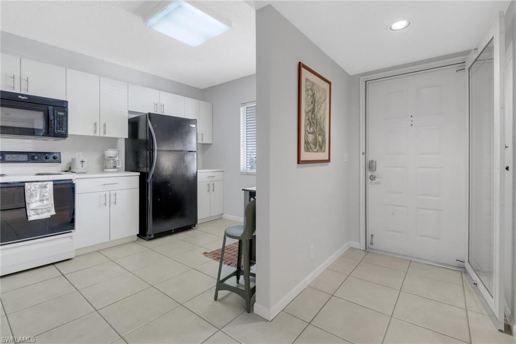 7791 Esmeralda Way, Unit L103 Naples, FL 34109 - Photo 4 of 46 a kitchen with stainless steel appliances a refrigerator sink and microwave