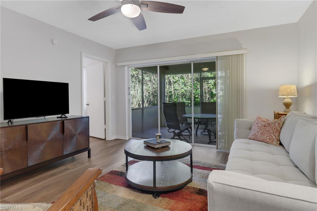 7791 Esmeralda Way, Unit L103 Naples, FL 34109 - Photo 10 of 46 a living room with furniture and a flat screen tv