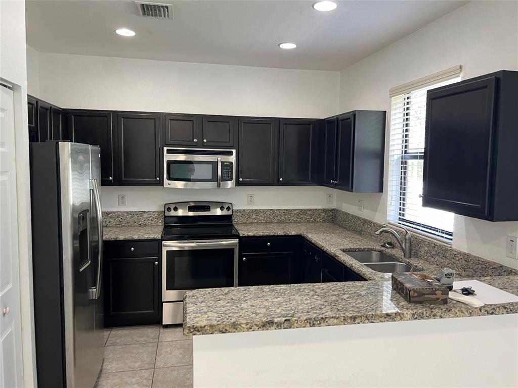 a kitchen with granite countertop wooden cabinets and stainless steel appliances