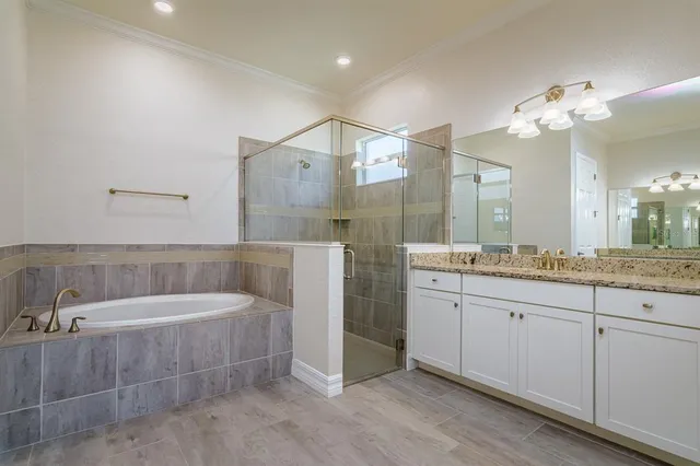 a bathroom with a tub a sink and mirror
