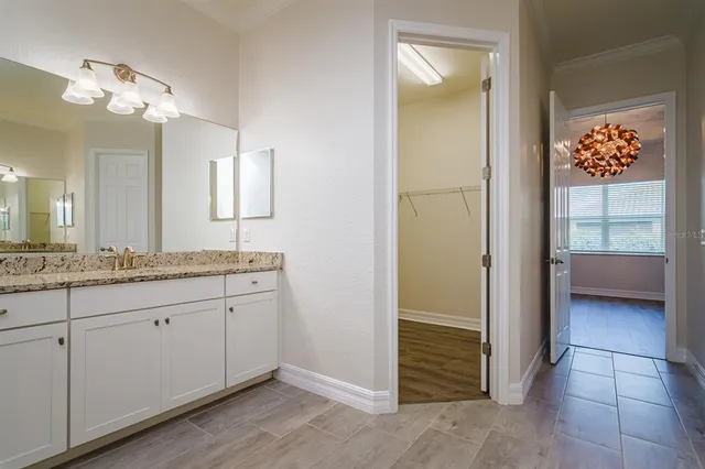 a bathroom with a granite countertop sink a mirror and a vanity