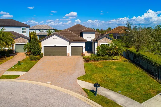 a view of a white house with a yard table and chairs