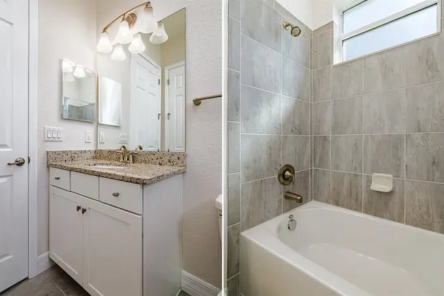 a bathroom with a granite countertop sink a large mirror and shower