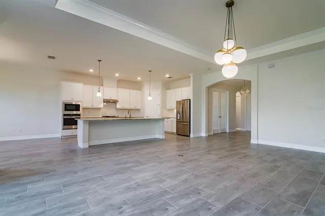 a view of an empty room and kitchen view