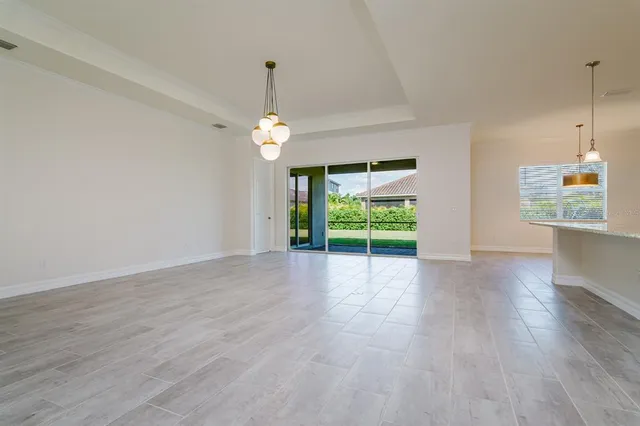 an empty room with wooden floor mirror and windows