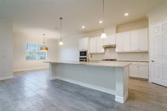 a kitchen with kitchen island white cabinets and stainless steel appliances