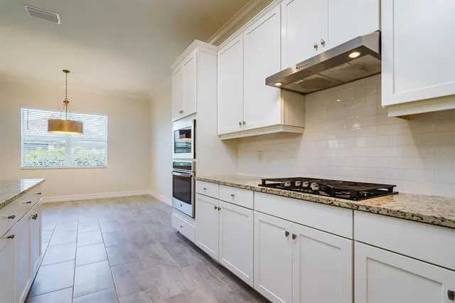 a kitchen with granite countertop a stove and a sink