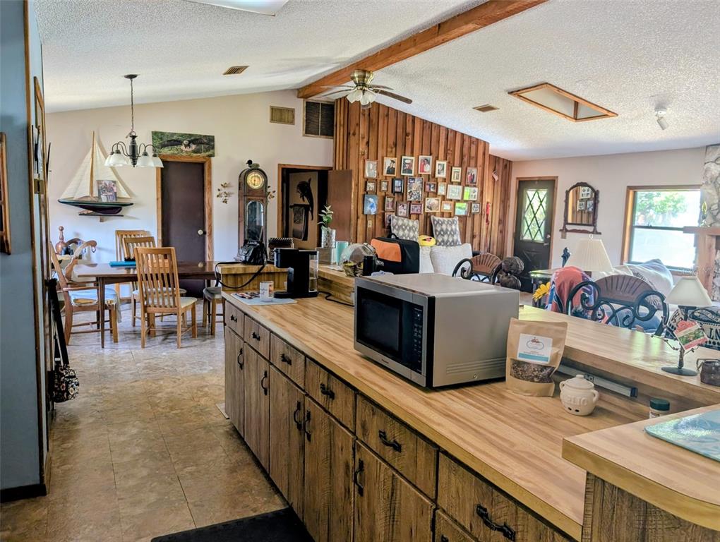 24514 Bonnet Road Astor, FL 32102 - Photo 20 of 37 a kitchen with stainless steel appliances kitchen island granite countertop a stove a sink dishwasher and white cabinets with wooden floor