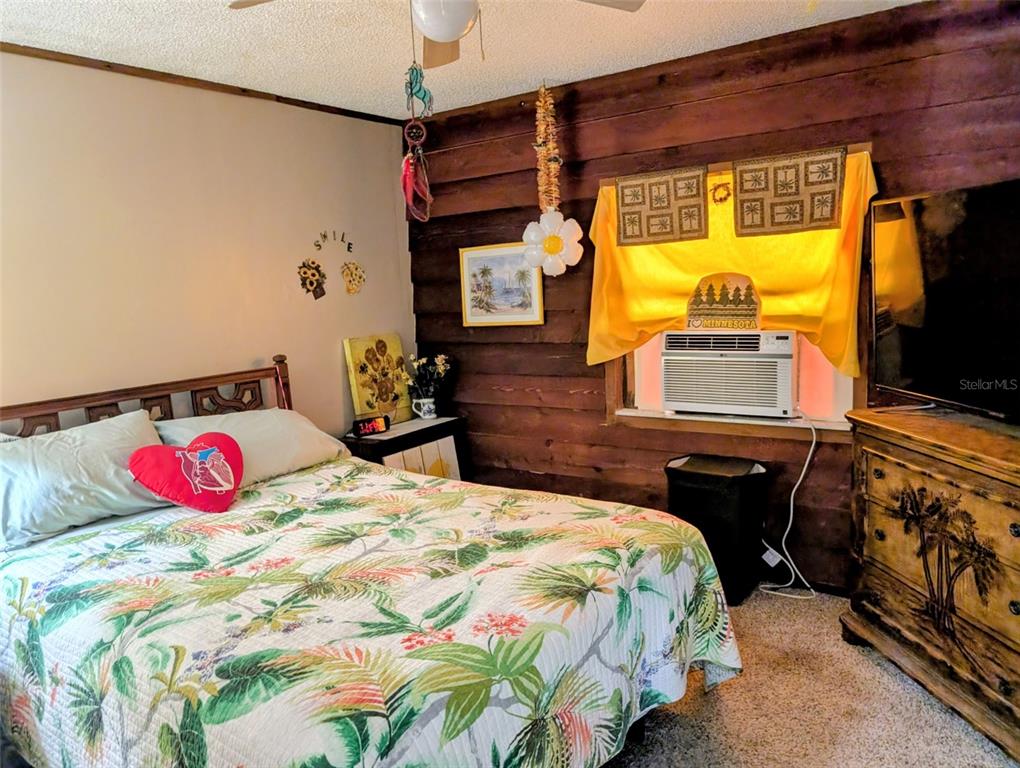24514 Bonnet Road Astor, FL 32102 - Photo 27 of 37 a bedroom with a bed and wooden floor