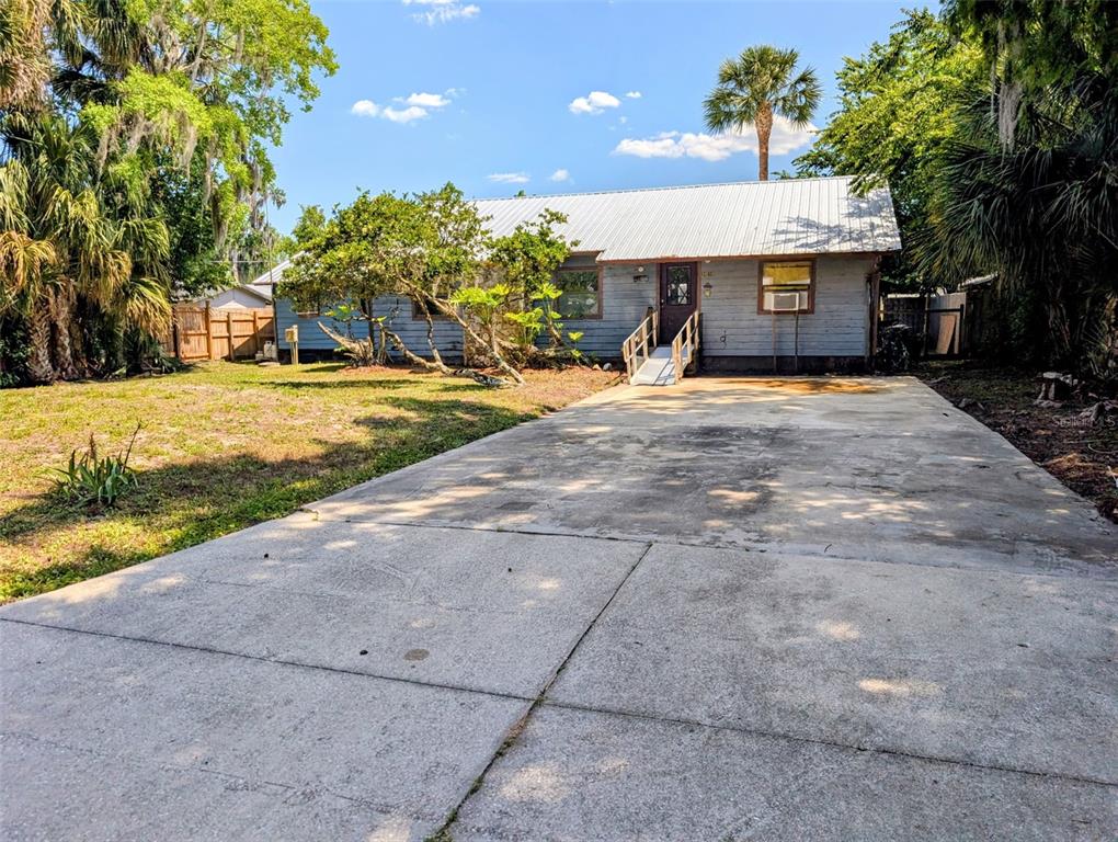 24514 Bonnet Road Astor, FL 32102 - Photo 3 of 37 a front view of a house with a yard and a garage