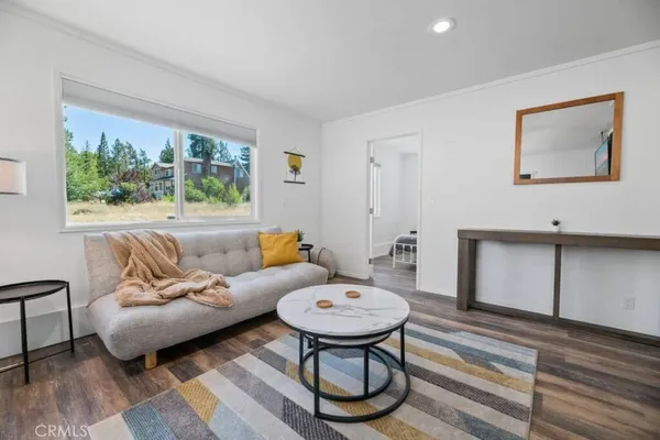 a living room with furniture a table and a large window