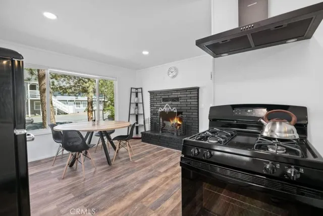 a kitchen with a stove a refrigerator and wooden floor