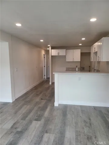 a large kitchen with stainless steel appliances a large counter top a stove and a refrigerator