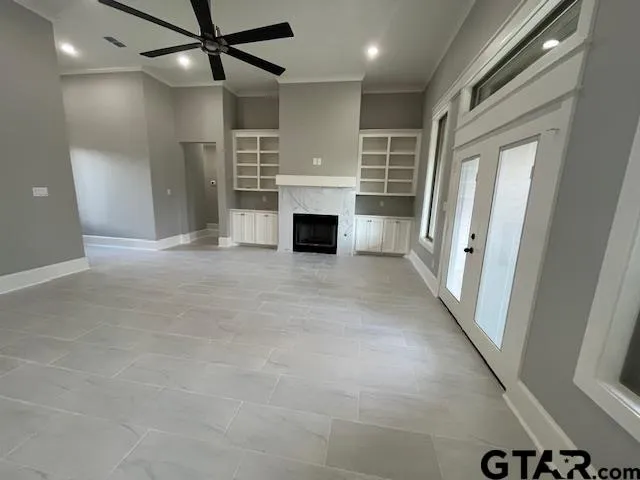 an empty room with windows and fireplace