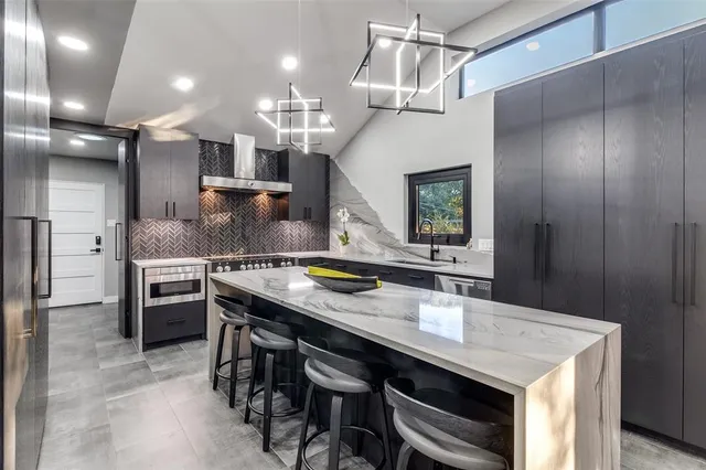 a kitchen with a sink a stove and chairs