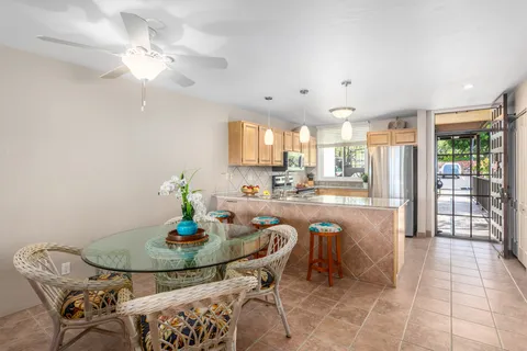 a kitchen with granite countertop a table chairs a stove a dining table and chairs