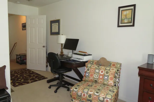 a view of a workspace with furniture and a window