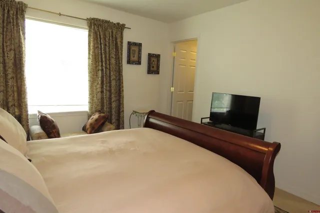 a bedroom with a bed and flat screen tv