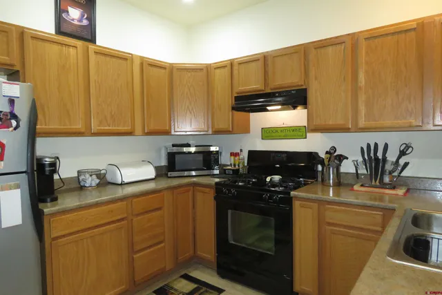 a kitchen with stainless steel appliances wooden cabinets sink and a stove