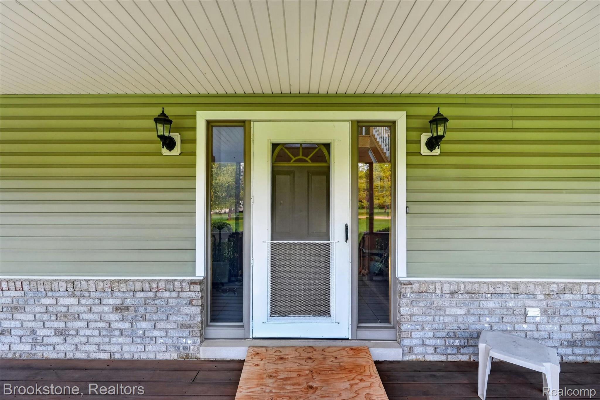 5163 Country Squire Road Dryden, MI 48428 - Photo 6 of 64 Covered porch entrance with light green horizontal siding and a white brick-look stone accent