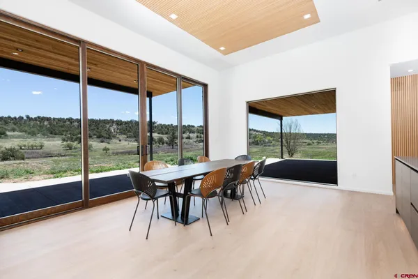 a dining room with furniture and a floor to ceiling window