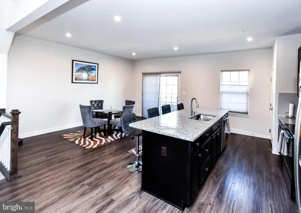 a dining hall with granite countertop a stove top oven a dining table with wooden floor