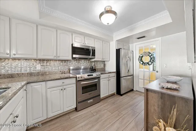 a kitchen with stainless steel appliances granite countertop a refrigerator stove microwave and sink