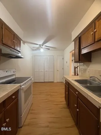 a kitchen with stainless steel appliances granite countertop a sink stove and cabinets