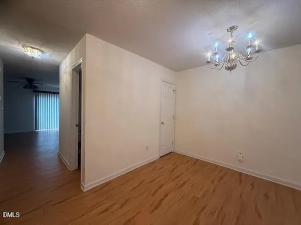 a view of a room with wooden floor and chandelier