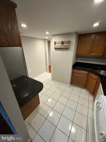 a view of an empty room and kitchen