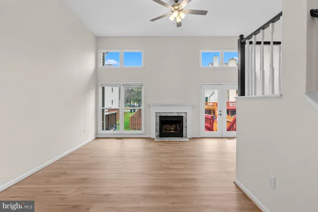 a view of a livingroom with a fireplace a chandelier and wooden floor