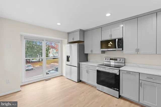 a kitchen with stainless steel appliances a stove sink microwave refrigerator and cabinets