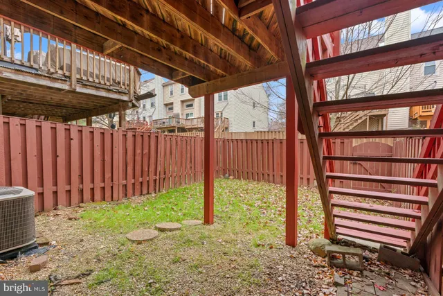 a view of a house with a small yard and wooden fence