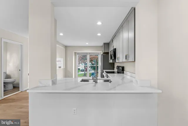 a kitchen with stainless steel appliances a sink and a refrigerator