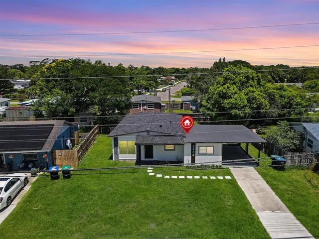 a aerial view of a house in a big yard with large trees